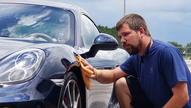 Careful polishing of a blue Porsche