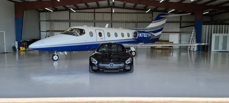 Black sports car and a private jet