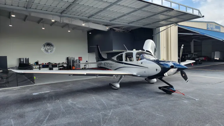Silver aircraft under hangar lighting